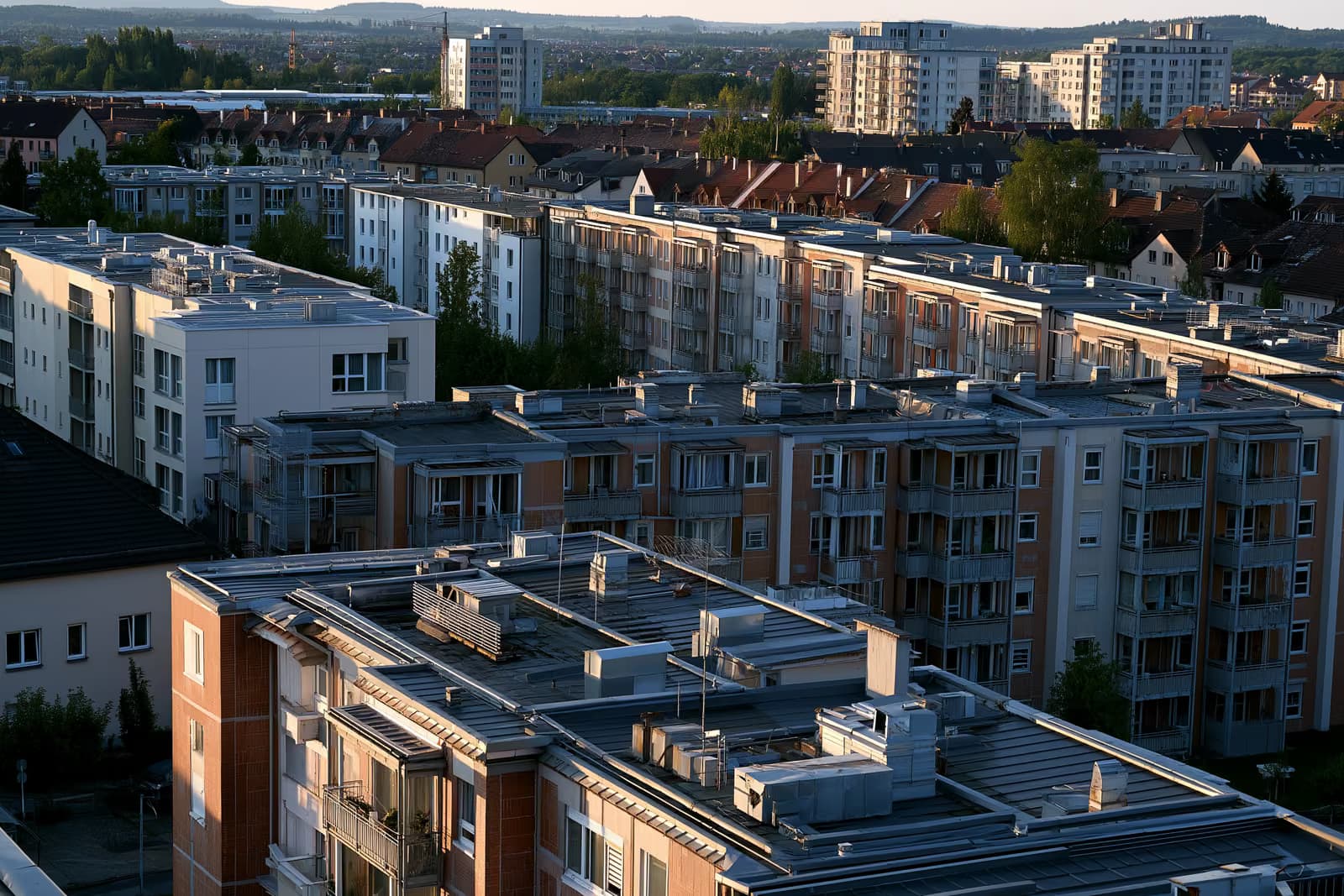 Azoteas y rejillas de ventilación de edificios de apartamentos residenciales en una ciudad alemana bajo la cálida luz de la tarde.