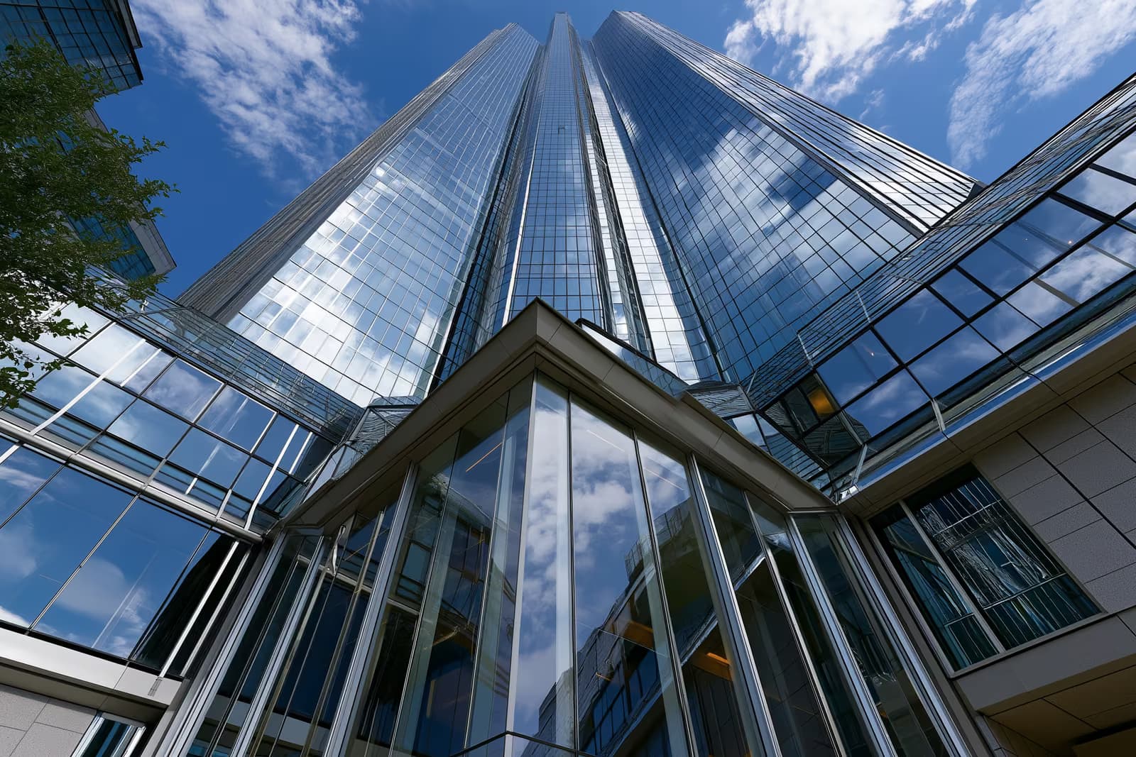 Una moderna torre bancaria de cristal en un distrito financiero alemán bajo un cielo despejado.